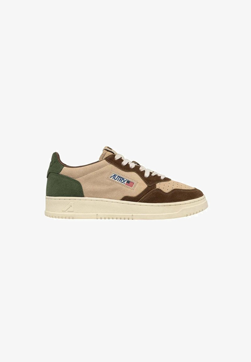 Scarpe da ginnastica in camoscio beige e marrone con accenti verdi, caratterizzate da una finitura testurizzata, punta arrotondata e lacci bianchi. Logo sul lato.