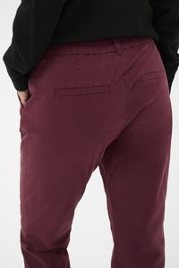 Burgundy trousers with a smooth texture, featuring two back pockets and a standard fit. Fabric has a slight sheen and tailored appearance.