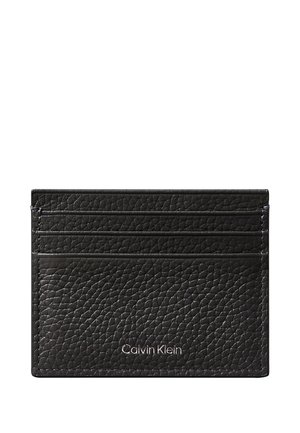 Black textured leather cardholder with four card slots and small silver Calvin Klein logo on front.