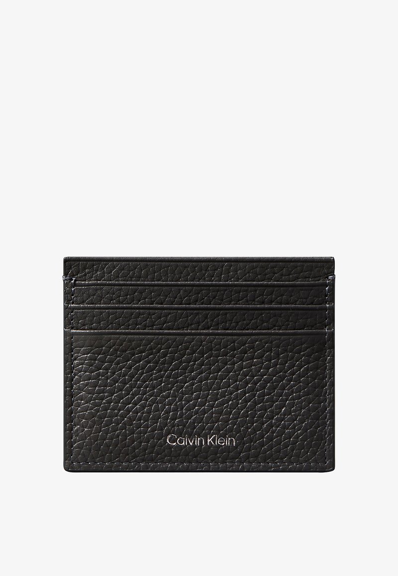 Porte-cartes en cuir noir texturé avec quatre emplacements pour cartes et petit logo Calvin Klein argenté sur le devant.