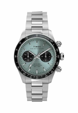Timex Waterbury kronográf óra rozsdamentes acél szíjjal, világoskék számlappal, két fekete segédszámlappal és fekete tachiméteres lünettával.