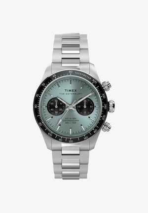 Zegarek chronograf Timex Waterbury z bransoletą ze stali nierdzewnej, jasnoniebieską tarczą, dwoma czarnymi subtarczami i czarnym pierścieniem tachymetru.