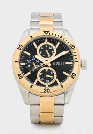 Montre-bracelet pour homme Guess avec cadran noir, bracelet en métal bicolore or et argent, trois sous-cadrans indiquant le jour, la date et l'heure sur 24 heures.