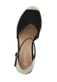 Espadrille noire avec un design floral découpé, semelle en jute tissé beige et une sangle de cheville avec boucle en métal. Doublure intérieure et semelle intérieure lisses.