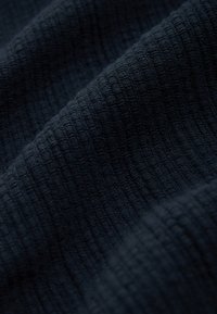 Mørk marineblåt tekstureret stof med et gittermønster. Materialet virker vævet med en blød og let hævet overflade.