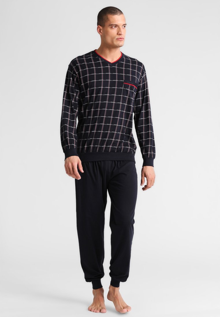 Heren lounge set met een marineblauwe lange mouw top met een ruitpatroon en rode accenten, gecombineerd met effen zwarte elastische broek met tailleband.