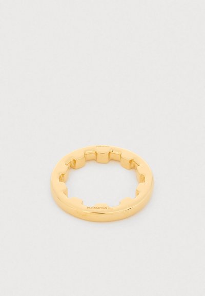 Prsten v zlaté tónině s hladkým povrchem a vnitřním vroubkovaným okrajem, na kterém je vyryto "PATTARAPHAN 925" a malé sériové číslo.