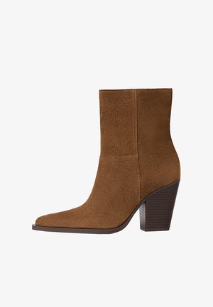 Smeđa antilop čizma do gležnja s šiljastim vrhom i složenim potplatom. Čizma ima glatku teksturu i bešavni dizajn bez vidljivih dijelova.