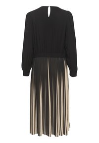 Svart långärmad klänning med en veckad beige kjol, med en cinchad midja och detalj i form av ett nyckelhål på baksidan, tillverkad av ett mjukt material.