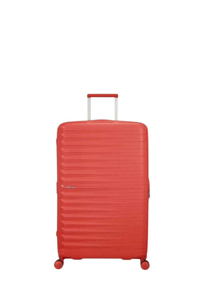 Valigia rigida rossa con un design testurizzato, caratterizzata da scanalature verticali e manico retrattile. Si muove su quattro ruote per una maggiore mobilità.