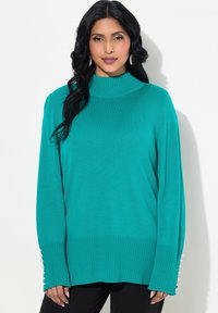 Türkisfarbener Pullover mit hohem Rippkragen, langen Ärmeln mit Perlenakzenten an den Bündchen und einer lockeren Passform.