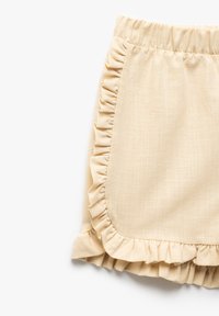Falda beis pálido hecha de tela texturizada, con un dobladillo con volantes y panel lateral. Cintura elástica para mayor comodidad al llevarla.