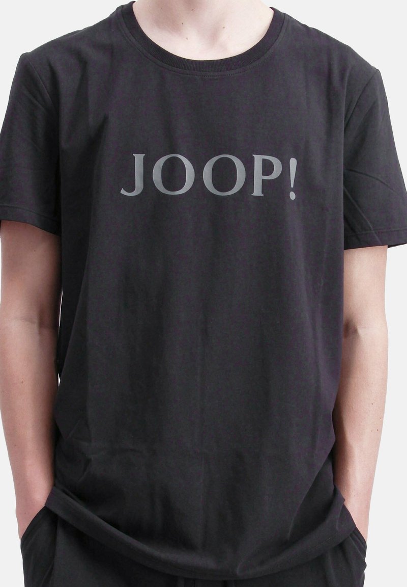 Camiseta de algodón negra con un gran logo gris "JOOP!" en el frente, con un cuello redondo y mangas cortas.