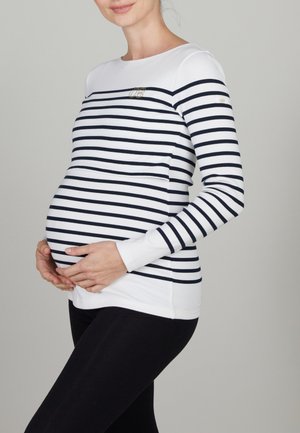 Chemise de maternité rayée en blanc avec des rayures marines, dotée de manches longues, d'un col rond et d'une coupe ajustée au niveau du ventre.