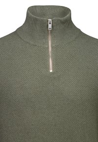 Maglione lavorato a maglia verde oliva con colletto alto a costine e una breve cerniera argentata al centro davanti.