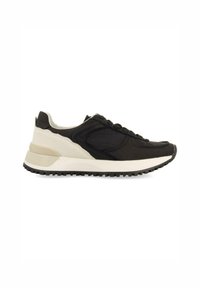 Zapato deportivo en blanco y negro con un upper texturizado, punta redonda y suela de goma. Presenta un diseño aerodinámico y acentos de color en contraste.