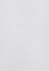 Tissu blanc avec un petit motif à carreaux tissé, montrant la texture et des ombres subtiles.