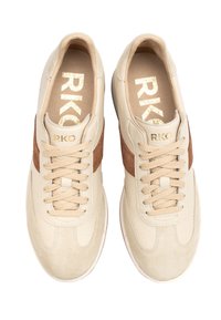 Beige ja pruuni nahast tossud paeltega ja "RKO" brändinguga keelel ja sisetalladel, nähtud ülevalt valgel taustal.