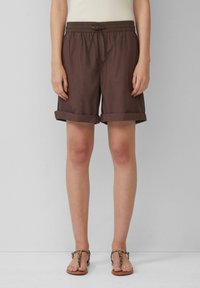 Bruine, middellange shorts met een elastische tailleband en een trekkoord. Omgeslagen zomen en lichtgewicht stof. Gecombineerd met sandaal in luipaardprint.