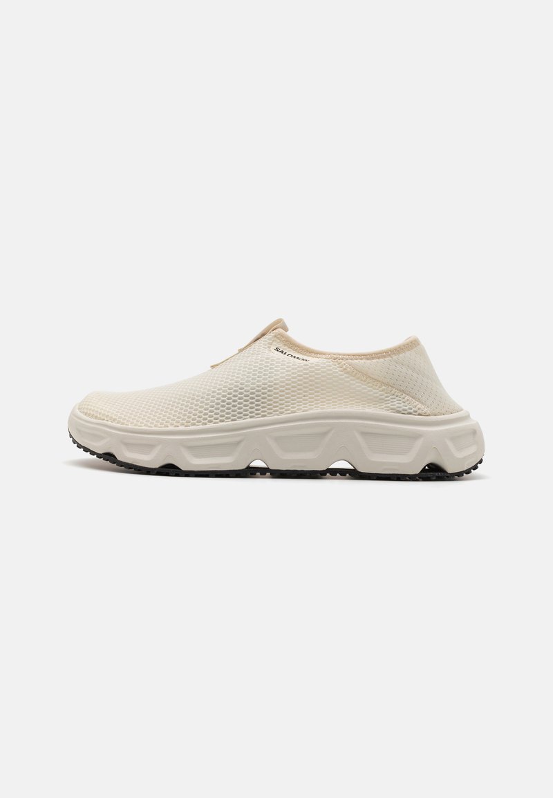 Chaussures en maille à enfiler de couleur crème avec un dessus texturé, une semelle noire contrastante et un design minimaliste. Pas de lacets ou de fermetures visibles.
