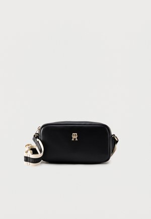 Sac bandoulière rectangulaire noir avec logo boucle dorée et sangle beige réglable avec détails de texte noirs.