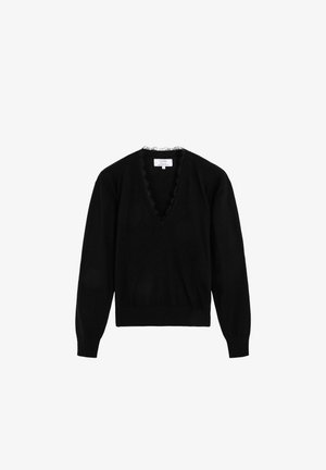 Suéter negro con un escote en V profundo, con un borde rizado alrededor del cuello. Mangas largas y dobladillo acanalado. Textura de punto suave.