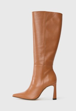 Brūni ādas ceļgalu augstie zābaki ar smailu purngalu, stiletto papēdi un gludu tekstūru; tiem ir elegants dizains ar minimālām šuvju detaļām.