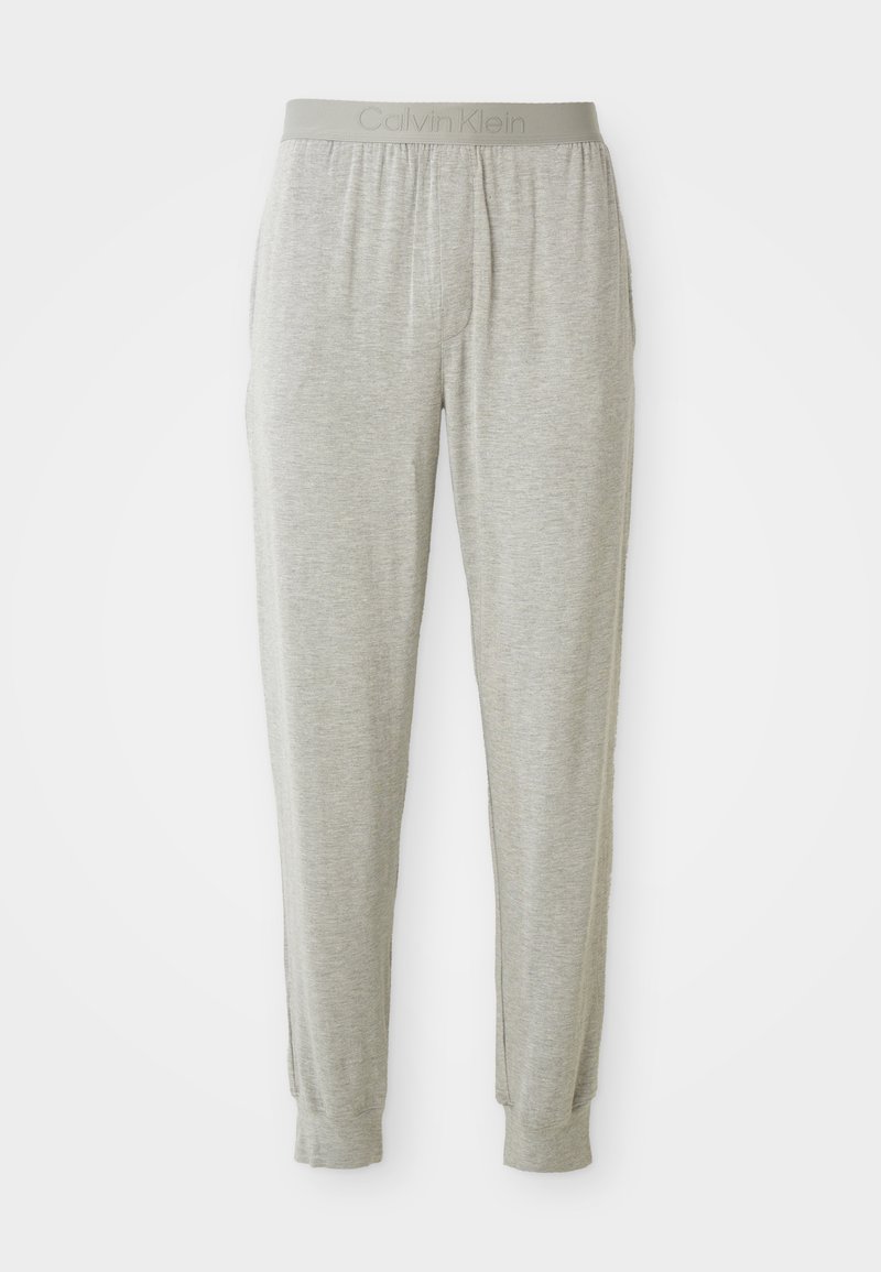 Pantaloni jogger gri deschis, confecționați dintr-un material moale, având un brâu elastic cu inscripția "Calvin Klein" embosată, manșete tăiate și fără buzunare vizibile.