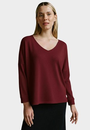 Burgundy long-sleeve top with a V-neck, relaxed fit, and soft texture. Features drop shoulders and ribbed cuffs.