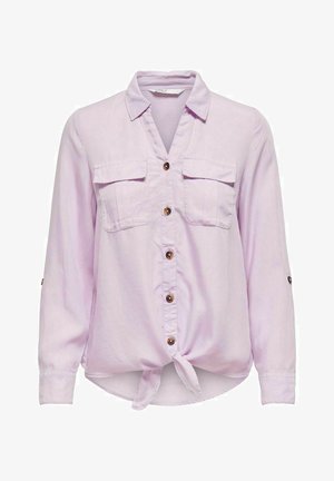Chemise lilas clair à manches longues en tissu doux. Présente des poches poitrine, un devant noué et des manches retroussables. Texture lisse, design décontracté.