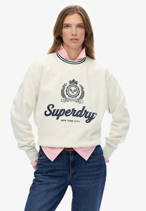 Sweatshirt crème en coton, avec un col rond orné de rayures noires et un logo navy ainsi qu'un design graphique proéminent sur le devant.