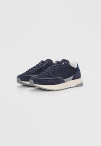 Navy sneakers with suede and mesh upper, gray accents, round toe, and rubber sole with textured tread pattern. Lace-up design.