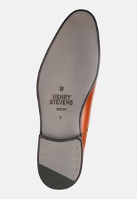 Suola di scarpa in pelle marrone con un lato grigio liscio, riportante il marchio "HENRY STEVENS BERLIN" e dettagli sulla taglia. Design con punta arrotondata.