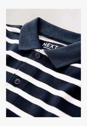 Navy plava polo majica s horizontalnim bijelim prugama, teksturiranim tkanjem, ovratnikom s gumbima i unutarnjom etiketu "NEXT". Dva crna gumba na kopči.