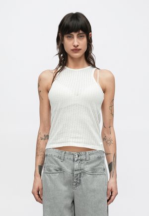 Hvit ribbet tanktopp med høy hals og smale stropper, med en tettsittende passform som går til rett over midjen.