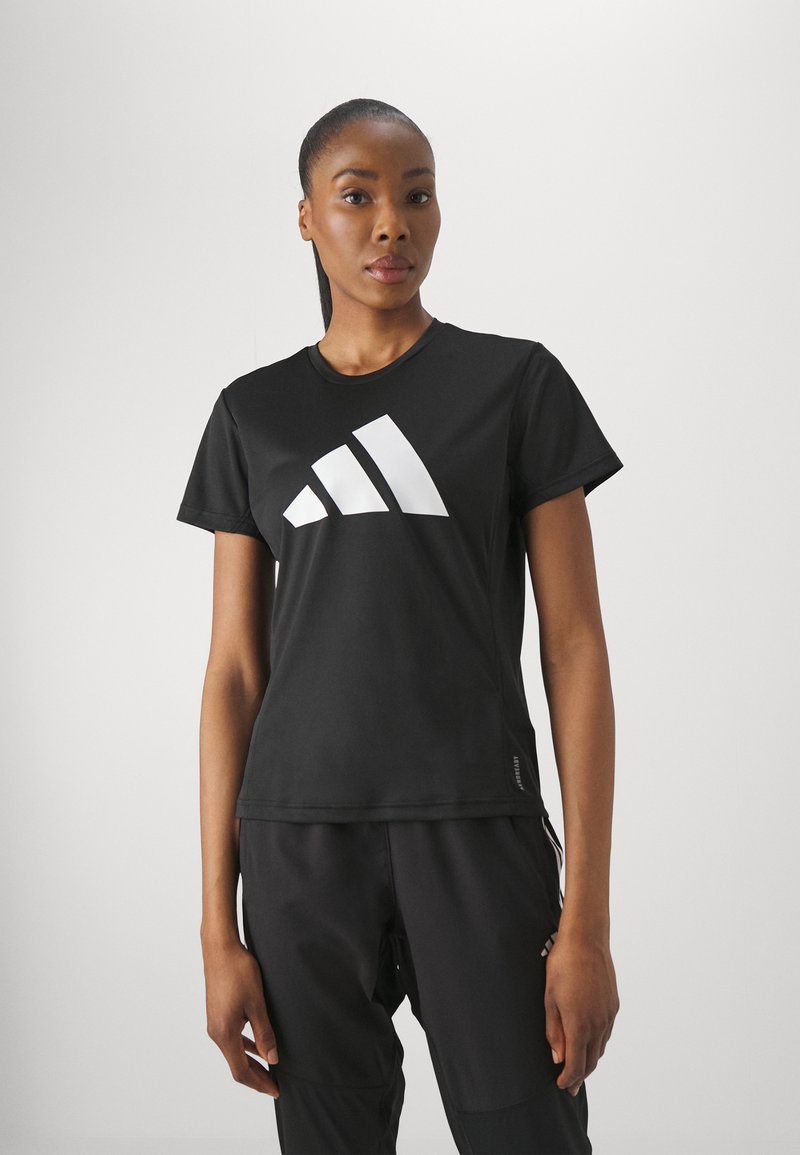 Must svart spordit-särk lühikeste varrukatega, ümmarguse kaelusega, millel on rinna peal suur valge Adidas'i logo, valmistatud sileda ja venivast materjalist.