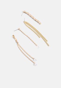 Quatre paires de boucles d'oreilles en métal doré : une barre texturée, deux chaînes en cascade et deux fils fins et plats, chacune avec des designs distincts.