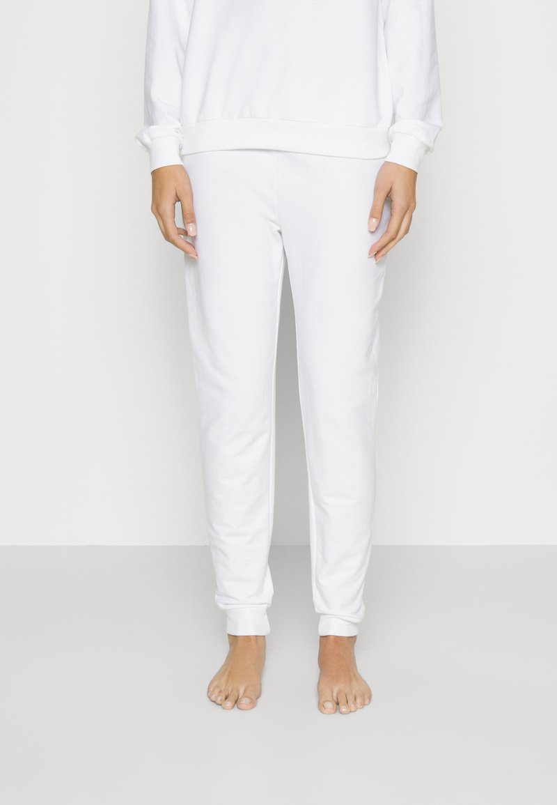 Witte katoenen joggingbroek met een taps toelopende pasvorm, elastische tailleband en gebreide enkels, met een gladde textuur en een minimalistisch ontwerp.