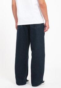 Dark blue wide-leg jeans made of denim, featuring a classic five-pocket design and a clean finish with minimal detailing.