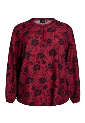 Blouse rouge à manches longues ornée de motifs floraux noirs et de pois, avec un col à boutons et une coupe décontractée.