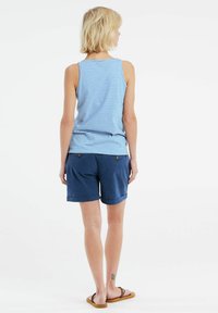 Canottiera a strisce blu e bianche con vestibilità ampia, abbinata a pantaloni corti blu navy con orlo risvoltato e due tasche posteriori.