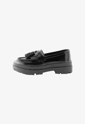Črne lakirane usnjene loaferske imajo pleteno detajliranje, sprednji trak z resicami in masiven gumijast podplat z utori za oprijem.