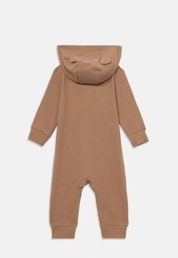 Brown long-sleeve baby jumpsuit with ribbed texture and hood featuring two small fabric ears, flat-lay view from back.