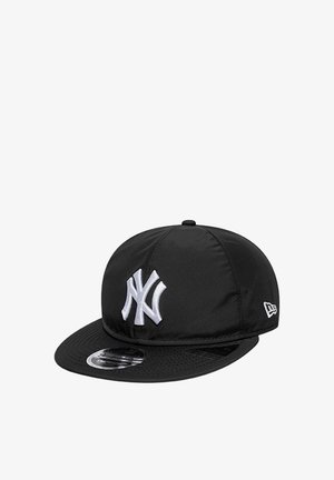Sort baseballkasket med hvidt broderet "NY" logo foran og flad skygge, med mærkesticker på skyggen.