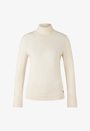 Krémový pletený svetr s dlouhým rukávem a rolákem, se žebrovanými manžetami a lemem, a malou černou cedulkou blízko spodního okraje.