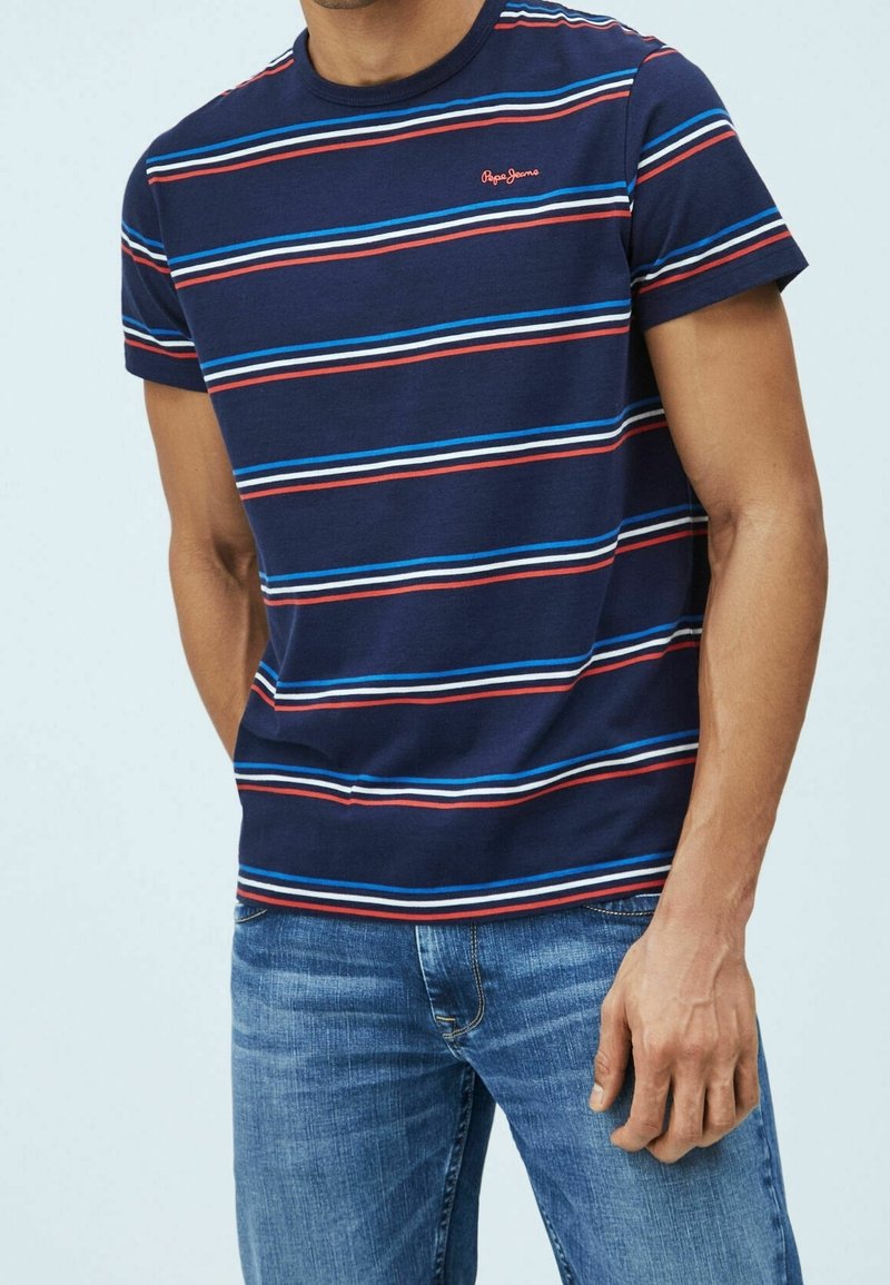 Camiseta de rayas azul y roja con cuello redondo, mangas cortas y un pequeño logo en el pecho; fabricada con una suave mezcla de algodón.