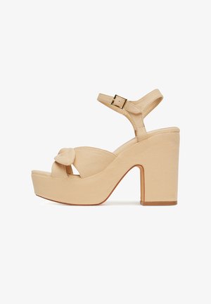 Béžové textilné platformové sandále s veľkou mašľou, otvorenou špičkou, nastaviteľným remienkom okolo členku a robustným podpätkom.