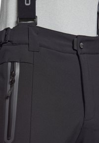 Pantalones de senderismo negros hechos de una tela elástica, con un bolsillo con cremallera, tirantes ajustables y un diseño elegante y aerodinámico.
