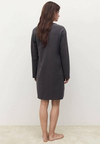 Abito lungo a maniche lunghe in carbone con vestibilità ampia, dotato di scollatura rotonda e texture morbida. Si ferma sopra il ginocchio, design minimalista.