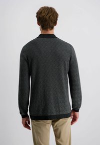 Herrenpullover in dunkelgrau mit Strickmuster, gerippten Bündchen und rundem Halsausschnitt, kombiniert mit beigen Hosen.